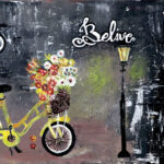 ציור של אופניים צהובים עם סל פרחים לצד פנס רחוב והמילה Believe על רקע כהה ומחוספס